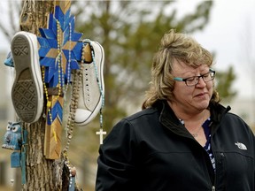 Kim Krupa, mother of 19-year-old Edmonton man Tanner Krupa, who was killed in Surrey, B.C., stands beside a tree planted in memory of her son in northeast Edmonton on Thursday April 18, 2019, where she and the RCMP pleaded for the public's help in finding her son's killer.