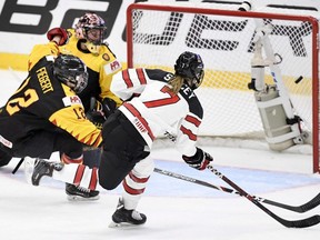 Laura Stacey of Canada (right) scores her team's third goal during a quarterfinal match against Germany at the IIHF Women's Ice Hockey World Championships in Espoo, Finland on Thursday, April 11, 2019.