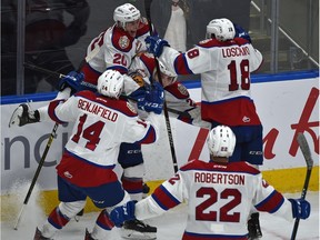 Edmonton Oil Kings teammates smother Jake Neighbours (21) after he scored the tying goal with 13 seconds left to force overtime against the Calgary Hitmen during WHL second round playoff action at Rogers Place in Edmonton, April 6, 2019.