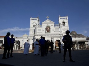 Sri Lankan air force officers and clergy stand outside St. Anthony's Shrine, a day after a blast in Colombo, Sri Lanka, Monday, April 22, 2019. Easter Sunday bombings of churches, luxury hotels and other sites was Sri Lanka's deadliest violence since a devastating civil war in the South Asian island nation ended a decade ago.
