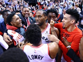 Kawhi Leonard #2 of the Toronto Raptors celebrates with teammates after sinking a buzzer beater to win Game Seven of the second round of the 2019 NBA Playoffs against the Philadelphia 76ers at Scotiabank Arena on May 12, 2019 in Toronto.