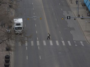 A pedestrian crosses 100 Street near 103 Avenue, in downtown Edmonton Thursday April 18, 2019.