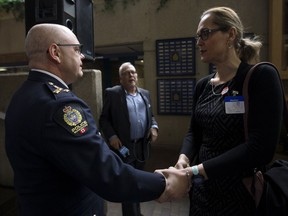 Edmonton Police Service Chief Dale McFee ishakes hands with LGBTQ activist Marni Panas after McFee apologized to the LGBTQ2S+ community at Edmonton Police Headquarters, in Edmonton Friday May 3, 2019. The apology is part of a reconciliation process with the EPS and members of the lesbian, gay, bisexual, trans, queer, and two-spirit community.