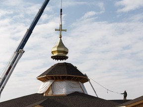 Ivan Lypovyk, site superintendent with Krawford Construction works on the roof to install the dome and top-cross of St. Sophia's Ukrainian Catholic Church in Strathcona County, on Wednesday, May 8, 2019. Photo by Ian Kucerak/Postmedia