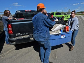 Some of the 4,000 High Level evacuees from the Chuckegg Creek fire, including Mathew Blaney and Courtanne Bolduc, load up possessions in the parking lot of the Legacy Centre where evacuees are registering in Slave Lake on Tuesday, May 21, 2019.