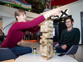 Joanne Iddings, left, plays Jenga with Nils Koropatnisky during Dark Matters: Game On! at the Telus World of Science on Thursday, May 16.