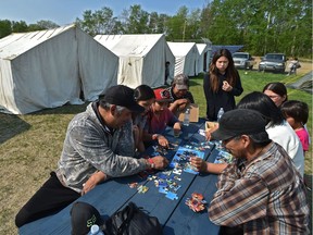 Parents try to keep the children busy putting a puzzle together at the Fort Vermilion Community and Culture Complex where about 300 Dene Tha' evacuees from the Chuckegg Creek wildfire are being housed on Friday, May 24, 2019.