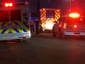 RCMP take a man in custody to a waiting ambulance behind Remax field on May 26, 2019