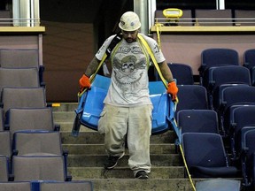A worker (Eric Navarro) removes seats at the former Northlands Coliseum on Thursday May 30, 2019. The City of Edmonton is selling 5000 pairs of seats for $230 a pair. Seats are being sold online at www.govplanet.com/coecoliseumseats.