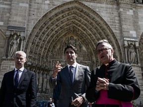 (From L) French Culture Minister Franck Riester, Canadian Prime Minsite Justin Trudeau and Notre Dame cathedral rector Patrick Chauvet speak after visiting the Notre Dame de Paris Cathedral in Paris on May 15, 2019, after it sustained major fire damage the previous month. - The April 15, fire destroyed the roof and steeple of the 850-year-old Gothic cathedral. Images of the ancient cathedral going up in flames sparked shock and dismay across the globe as well as in France, where it is considered one of the nation's most beloved landmarks.