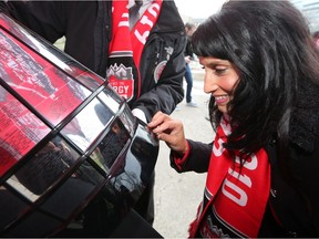 Leela Aheer, Minister of Culture, Multiculturalism and Status of Women, checks out the Grey Cup during the 2019 Grey Cup Kickoff Breakfast in Calgary's Olympic Plaza on Tuesday May 7, 2019.