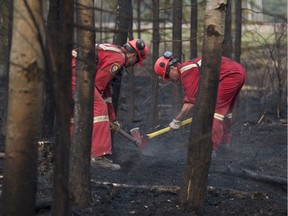 Crews battle the Chuckegg Creek fire near the town of High Level in late May, working to put out hotspots on the periphery of the fire.