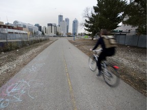 A cyclist makes their way along the bike path that runs beside the LRT tracks between 96 Street and 95 Street and 105 Avenue and 106 Avenue, in Edmonton Monday Oct. 15, 2018.