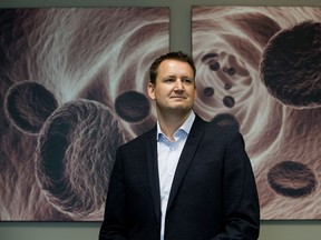 Dynalife Medical Labs CEO Jason Pincock in front of an image of red blood cells at the company's downtown headquarters on Friday, May 24, 2019.