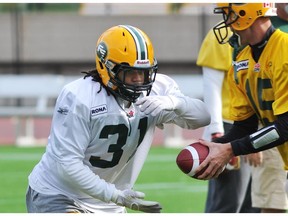 Calvin McCarty takes a hand-off from Ricky Ray during an Edmonton Eskimos practice at Commonwealth Stadium in Edmonton on Sept. 6, 2011.