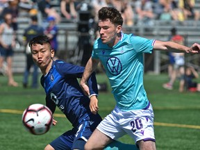 FC Edmonton's Son Yong-Chan (7) and Pacific FC's Emile Legault (20) battle for the ball during Canadian Premier League action at their home opener at Clarke Stadium in Edmonton, May 12, 2019.