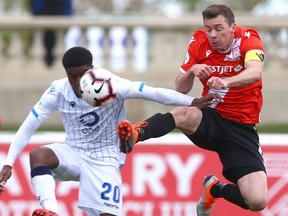 FC Edmonton's Bruno Zebie (L) competes with Cavalry FC Nik Ledgerwood during second half CPL soccer action between FC Edmonton and Cavalry FC in Calgary at Atco Field at Spruce Meadows on Saturday, May 18, 2019. Cavalry won 1-0 and remain undefeated.