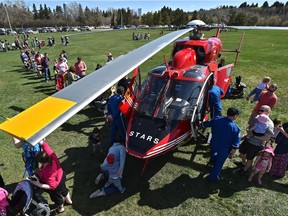 Parents lineup with their children to get a peep inisde the STARS helicopter on display during the 12th annual Get Ready in the Park which provides Edmontonians with an opportunity to learn how to prepare for and deal with major emergencies and disasters in Edmonton, May 11, 2019.