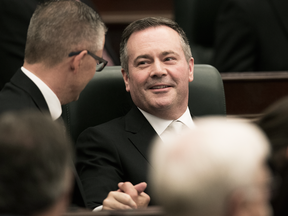 Alberta Premier Jason Kenney is congratulated by Finance Minister Travis Toews following the opening of the first session of the 30th Alberta Legislature, in Edmonton on May 22, 2019.
