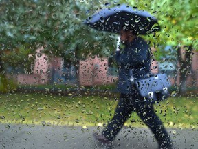 A man walks in the rain in Edmonton, September 26, 2018.