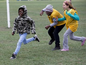 Grade 5 Recess Guardians Hamza Saccoh and Danika Sawchuk play tag with  kindergarten student Okuomose Prosper, left, at Balwin School on Thursday, May 23, 2019.