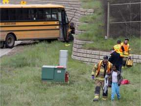 Emergency crews respond to a school bus crash along the Whitemud Drive near 149 Street, in Edmonton Thursday May 23, 2019. Eleven children and one adult were transported to hospital after a school bus carrying 23 children struck a concrete retaining wall on the east side of the freeway.