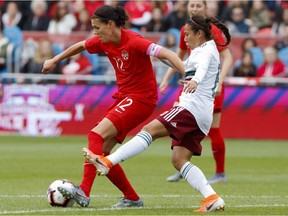 Team Canada captain Christine Sinclair tries to keep the ball away from Team Mexico midfielder Karla Nieto during the first half of a women's international soccer friendly at BMO Field in Toronto, Saturday, May 18, 2019.