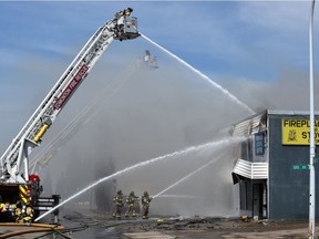 Firefighters battle a blaze that broke out 168 Street and 100 Avenue about 1:24 p.m. at the Fireplace & Stove Centre on Friday, May 17, 2019.