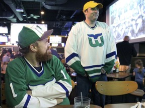 Scott St. Laurent, left, and Matthew Greene chat with other members of the Hartford Whalers Booster club, Thursday, May 9, 2019, at a restaurant in Manchester, Conn. They had gathered to watch Game 1 of the NHL Eastern Conference playoff series on between the Carolina Hurricanes, the franchise that moved from Hartford 22 years ago, and the Boston Bruins.