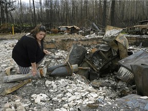 Paddle Prairie Metis Settlement resident Wilma Cardinal sifts through the remains of her sister-in-law's home on Wednesday June 19, 2019. A wildfire destroyed at least fifteen homes on the settlement, located 80 kilometres south of High Level, Alberta.