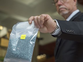 Acting Staff Sgt. Guy Pilon holds a bag of fentanyl during a July 24, 2018, press conference at Edmonton police headquarters. Alberta's Court of Appeal heard a case Wednesday on whether two fentanyl traffickers' sentences should be increased, raising the possibility of a "starting point" sentence for high-level fentanyl dealers.