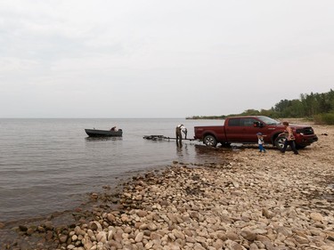 A boater is seen on the lake as a wildfire evacuation alert continues near the town of Slave Lake, on Saturday, June 1, 2019.