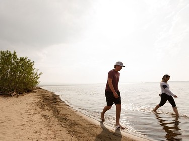 A couple walk along Devonshire Beach as a storm rolls during a wildfire evacuation alert continues in the town of Slave Lake, on Saturday, June 1, 2019. Photo by Ian Kucerak/Postmedia