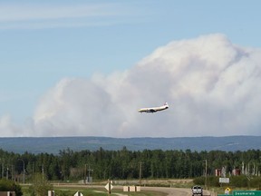 The McMillan Complex wildfires are seen burning from Slave Lake, Alberta as an air tanker lands on June 2, 2019. Photo by Ian Kucerak