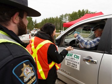 Residents receive welcome home packages at the roadblock while heading into High Level, Alberta, after being evacuated due to the Chuckegg Creek wildfire on Monday, June 3, 2019.