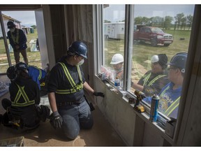 Darren Morin, in Grade 11 insulates one of the homes nearing completion. Ermineskin Cree Nation's Housing through Education program is in the process of construction three homes for Elders in the community with labour from three schools. The students learn on the job construction skills at Ermineskin Cree Nation on June 5, 2019. Photo by Shaughn Butts / Postmedia