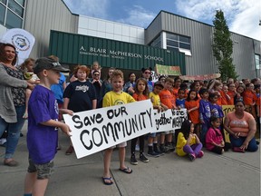 Parents with their children out front A. Blair McPherson School show their anger on June 14, 2019, at the potential removal of junior high grades from that school to another new school.