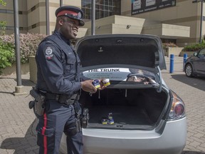 Constable Dexx Williams, cannabis compliance officer with the Edmonton police pictured on June 18, 2019, reminding Edmontonians to keep their cannabis out of reach in their vehicles. Photo by Shaughn Butts / Postmedia