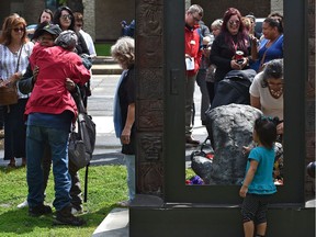 People lay commemorative flowers at the 14th annual service to honour people, 95 for 2018, who have died in situations of homelessness or poor housing at the Homeless Memorial Plaza  across from city hall in Edmonton, June 26, 2019. Ed Kaiser/Postmedia