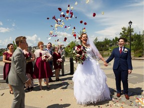 Alex Panas, 12, throws flower petals into the air during the marriage of parent Marni Panas and Kate Beneteau at Patricia Lake Park in Edmonton, on Sunday, June 30, 2019.
