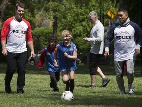 Children play soccer with police officers during the Bend it with the Beat Police Appreciation event at Giovanni Caboto Park, in Edmonton Saturday June 8, 2019.