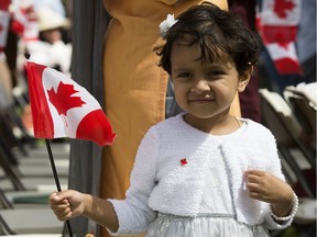 A young girl watches the Canada Day citizenship ceremony at the Alberta Legislature, in Edmonton Sunday July 1, 2018.