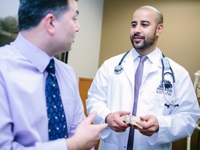 Dr. Nathan Thakur, Medical Director, Copeman Healthcare Edmonton, right, discusses men's health with a patient.