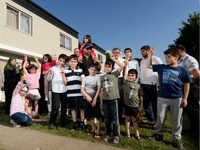 Members of multiple Syrian families who have made their lives in Edmonton outside a home on Monday, June 17, 2019. Ten families from Idlib are building new lives in the city.
