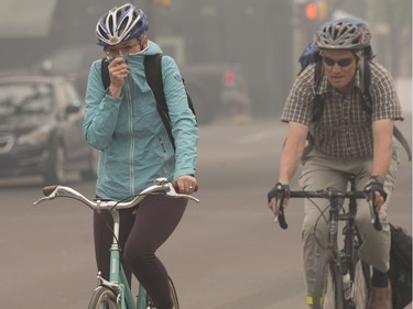 Cyclists make their way through the smoke near 104 street and 83 Avenue, in Edmonton Thursday May 30, 2019. Smoke from northern wild fires has blanketed the Edmonton region. Photo by David Bloom