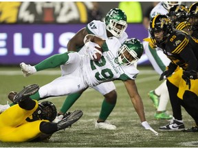 Saskatchewan Roughriders William Powell is tackled by Hamilton Tiger Cats Ja'Gared Davis during second half CFL football game action in Hamilton on June 13, 2019.