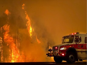 Fire crews work to ensure a controlled burn doesn't cross Highway 35 on May 22, 2019. Pictured is High Level Engine 3 stationed across from the lumber mill Norbord Inc., at risk from falling embers.