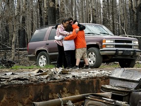 Paddle Prairie Metis Settlement residents Angie and Ronnie Cardinal and their children are overcome with grief after seeing the remains of their home on Thursday June 20, 2019. All residents of the community were evacuated four weeks ago when a wildfire swept through Alberta's largest Metis settlement and destroyed at least fifteen homes. None of the residents had insurance for their homes. The settlement is located 660 kilometres north of Edmonton, Alberta. (PHOTO BY LARRY WONG/POSTMEDIA)