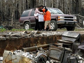 Paddle Prairie Metis Settlement residents Angie and Ronnie Cardinal and their children are overcome with grief after seeing the remains of their home on Thursday June 20, 2019. All residents of the community were evacuated four weeks ago when a wildfire swept through Alberta's largest Metis settlement and destroyed at least fifteen homes. None of the residents had insurance for their homes. The settlement is located 660 kilometres north of Edmonton, Alberta. (PHOTO BY LARRY WONG/POSTMEDIA)