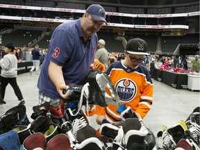 Kelly Krause and his son Bryce Krause, 12, check out the hockey skates up for sale during the 13th annual Edmonton Oilers Locker Room Sale at Rogers Place, Saturday June 8, 2019.